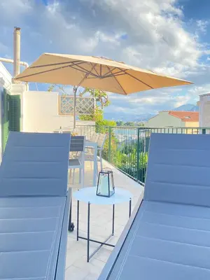 a patio with a table and an umbrella at The White Sail - Mondello Apartment with Terrace - casa di vincenzo e andrea in Mondello