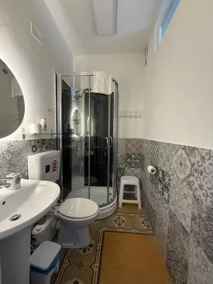 a bathroom with a shower and a toilet and a sink at GUEST HOUSE BOSCO in Palermo