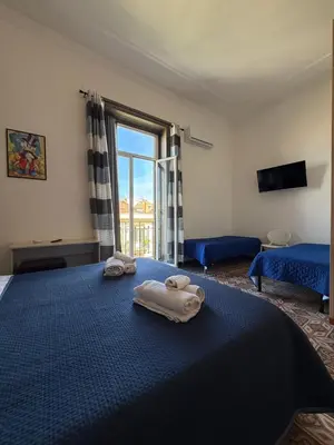 a bedroom with two towels on a bed with a window at GUEST HOUSE BOSCO in Palermo