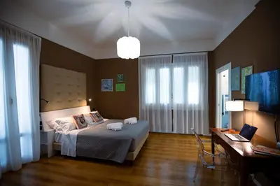 a bedroom with a bed and a desk with a laptop at Villa Calipso in Mondello