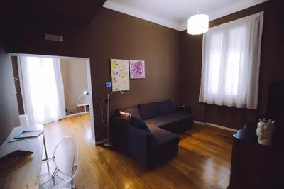 a living room with a couch and two windows at Villa Calipso in Mondello