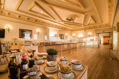 a large room with a table with dishes and wine bottles at Grand Hotel Wagner in Palermo