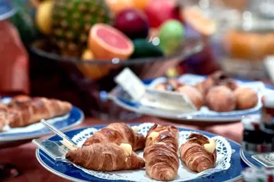 a table topped with plates of pastries and fruit at Grand Hotel Wagner in Palermo