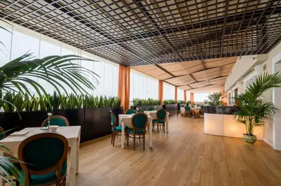 a restaurant with tables and chairs and plants at Grand Hotel Wagner in Palermo
