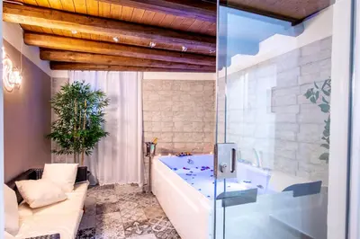 a bathroom with a tub and a glass door at Principe di villafranca Suite in Palermo