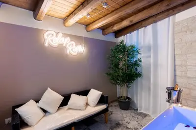 a living room with a couch and a neon sign at Principe di villafranca Suite in Palermo