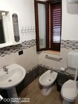 a bathroom with two sinks and a toilet and a mirror at Stella marina in Buonfornello