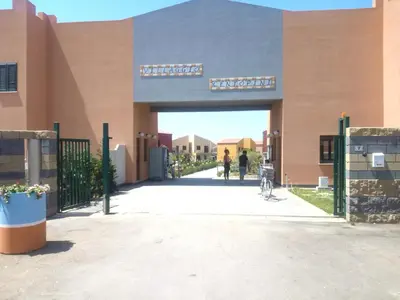 a building with a gate and a person walking through it at Stella marina in Buonfornello