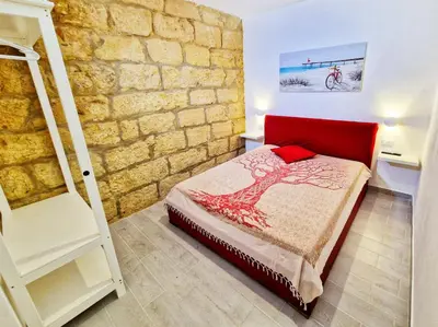 a bedroom with a bed and a brick wall at Casa vacanze A&G in Castellammare del Golfo