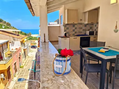 a kitchen with a table and a view of the ocean at Casa vacanze A&G in Castellammare del Golfo