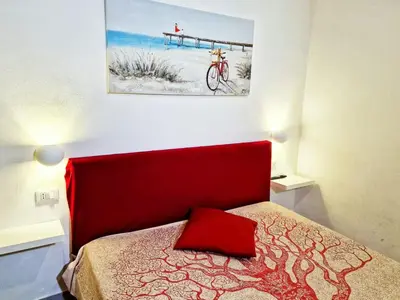 a bed with a red headboard in a bedroom at Casa vacanze A&G in Castellammare del Golfo