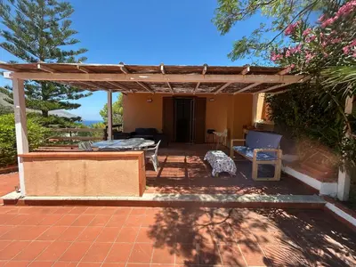 a patio with a pergola and a table and chairs at Like Home Calamazzo di Sciacca in Scopello