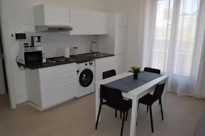 a kitchen with a table and a stove and a sink at Domus Levante in Terrasini