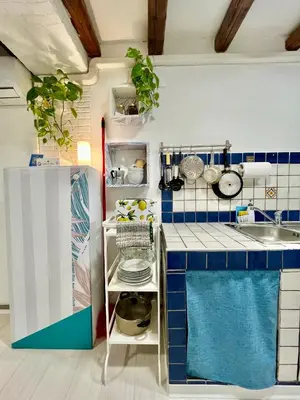 a small kitchen with blue and white tiles at Casa Myrtos in Palermo