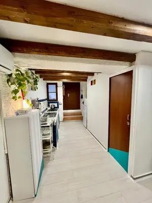 a kitchen with white walls and wooden ceilings at Casa Myrtos in Palermo