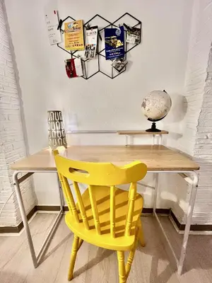 a yellow chair sitting in front of a wooden table at Casa Myrtos in Palermo