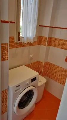 a washing machine sitting next to a toilet in a bathroom at Dudi Apartment in Palermo