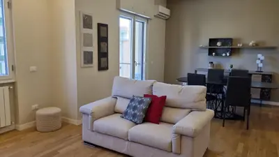 a living room with a couch and a dining room at Dudi Apartment in Palermo