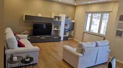 a living room with two white couches and a television at Dudi Apartment in Palermo