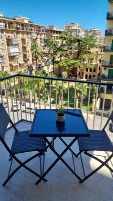 a blue table and two chairs on a balcony at Dudi Apartment in Palermo