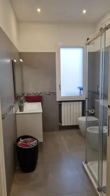 a bathroom with a sink and a toilet and a window at Dudi Apartment in Palermo