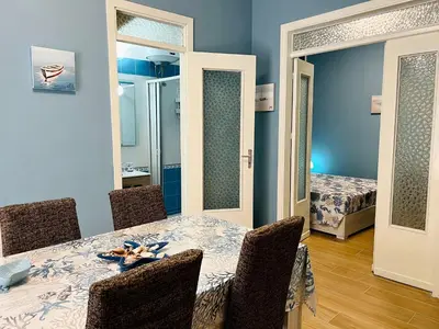 a dining room with a table and chairs and a bedroom at Casa del Pescatore in Isola delle Femmine