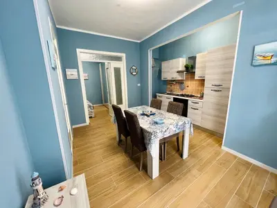 a dining room with blue walls and a table and chairs at Casa del Pescatore in Isola delle Femmine