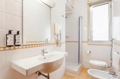 a white bathroom with a sink and a toilet at Crisol Europa in Palermo