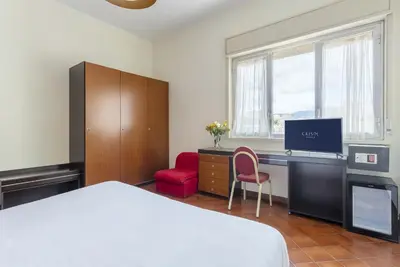 a bedroom with a bed and a desk with a tv at Crisol Europa in Palermo