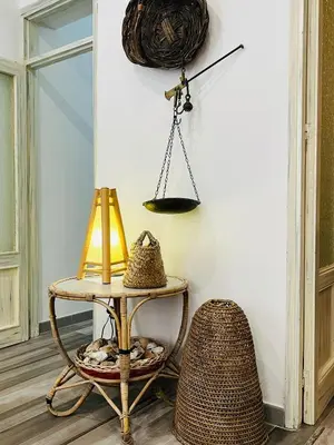 a table with a lamp and a rattan chair at Covo del pescatore in Bagheria
