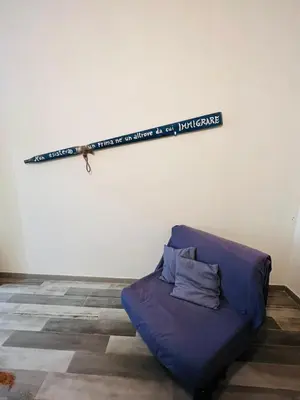 a couch in a room with a sign on the wall at Covo del pescatore in Bagheria