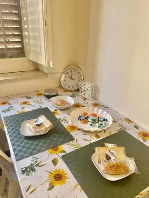 a table with plates of food on it with a clock at Apartament Dimora di Maury a due passi dai trasporti e da Ballarò in Palermo