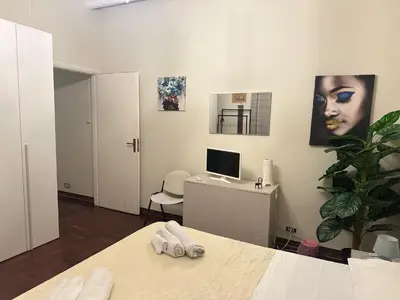 a bedroom with a bed and a desk with a computer at Apartament Dimora di Maury a due passi dai trasporti e da Ballarò in Palermo