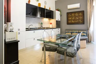 a kitchen and dining room with a glass table at Hola Cathedral House Porta di Castro in Palermo