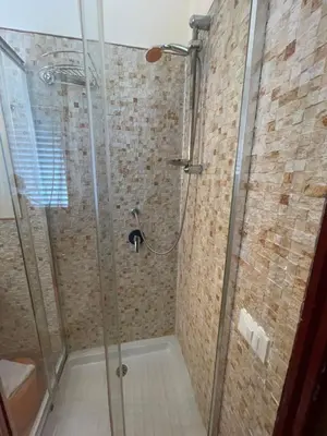 a bathroom with a shower with a glass door at Hola Cathedral House Porta di Castro in Palermo