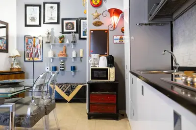 a kitchen with a counter and a table and a sink at Hola Cathedral House Porta di Castro in Palermo