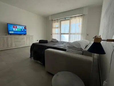 a bedroom with a bed and a couch and a television at MC Rooms in Torretta