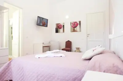 a bedroom with a pink bed with two towels on it at Villa San Vito Bay in Macari