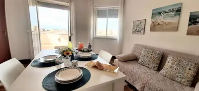 a living room with a table and a couch at Dune Dorate,Tramonti Infiniti la tua oasi di pace in Dune ! Aprile al Mare in Appartamento con vista panoramica e WiFi Casa Vacanza Vista Mare in Sicilia Relax e Tramonti Unici in Alcamo Marina