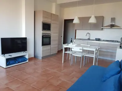a kitchen and dining room with a table and chairs at Villa delle Pomelie - Castellammare del Golfo in Alcamo