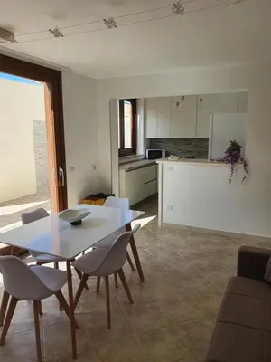 a kitchen and dining room with a table and chairs at Dancing Apartment in Castelluzzo