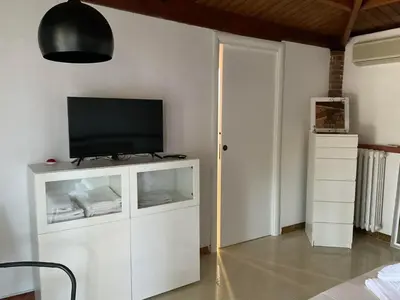 a living room with a television on a white cabinet at la Casetta di Laura in Terrasini