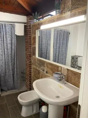 a bathroom with a sink and a toilet and a mirror at la Casetta di Laura in Terrasini
