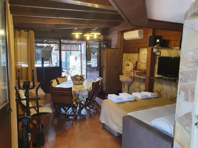 a dining room with a table and chairs and a television at La Dependance delle Mimose in Isola delle Femmine