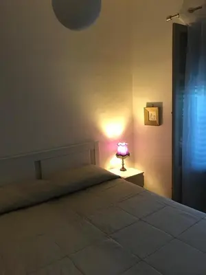 a bedroom with a bed and a lamp on a table at Casa Delizia in Lido di Mondello