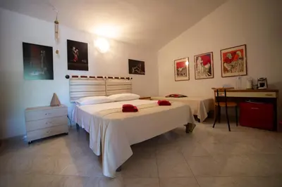 a bedroom with two beds and a desk in it at Le Yucche in Partinico