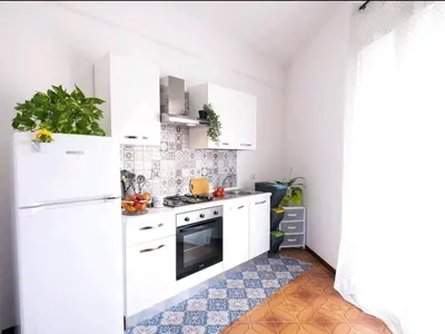 a kitchen with white appliances and a tile floor at Limoncello Apri la finestra e respira il profumo del mare Alloggio Spazioso in Sicilia Comfort per 6 Ospiti in Castellammare del Golfo