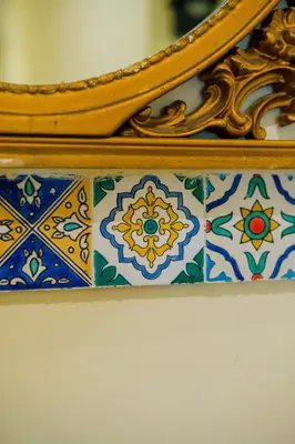 a mirror on top of a wall with colorful tiles at Le Stanze dei Tesori - Luxury Rooms in Palermo