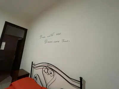a bedroom with a bed with a writing on the wall at Maya Palace Real Rooms Palermo centre close to Cathedral in Palermo