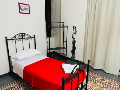 a bedroom with a bed with a red blanket at Maya Palace Real Rooms Palermo centre close to Cathedral in Palermo